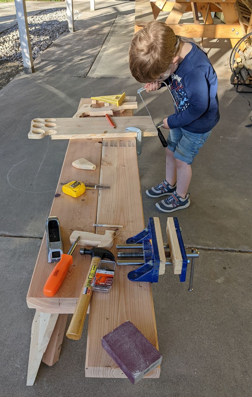 kid woodworking at low work bench